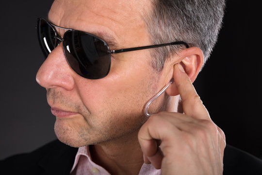 Male Security Guard Listening To Earpiece