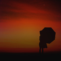 Umbrella little girl stand and sunset silhouette.