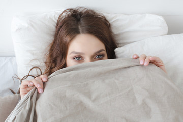 Female lying covered with blanket