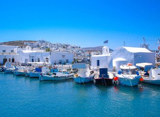 Traditional fishing boats mooring in front of a small church in Naoussa port, Paros island, Greece
