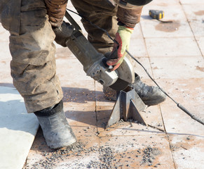 Worker cuts metal in the park