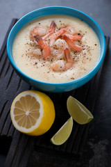 Close-up of potato cream-soup with king shrimps served in a blue bowl