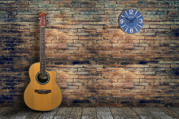 acoustic guitar in empty room with  brick wall