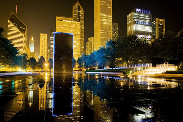 Chicago night view. Beautiful summer night in the center of Chicago. Downtown lights and illuminated skyscrapers reflected in puddles after rain.