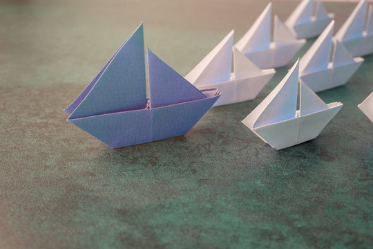 Origami Paper Sailboats, Success Leadership, Strategy Planning Development, Social Media Influence Marketing, HR Recruiter, Disruptive Innovation, Following Competition, New Normal Concept.