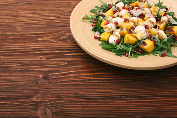 Salad with arugula, mango, cheese and pomegranate