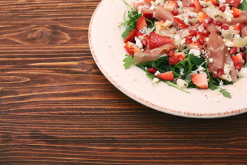 Arugula salad with strawberries, feta cheese, prosciutto, parmes