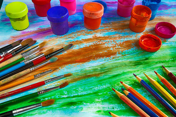 Artistic brushes, pencils and colored ink on colored background of avant-garde
