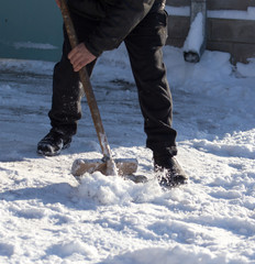 Worker cleans snow shovel