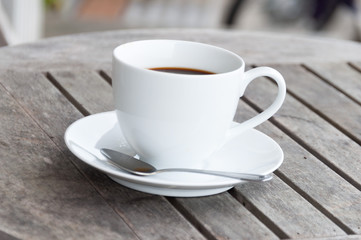 white cup of coffee on wooden table, soft focus