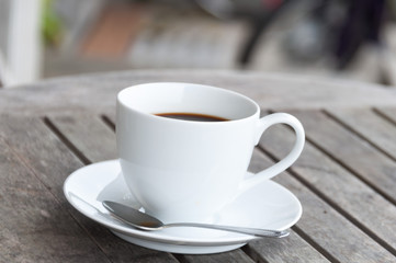 white cup of coffee on wooden table, soft focus