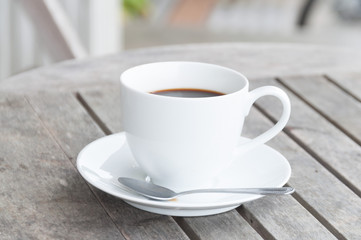 white cup of coffee on wooden table, soft focus