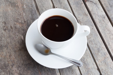 white cup of coffee on wooden table, soft focus