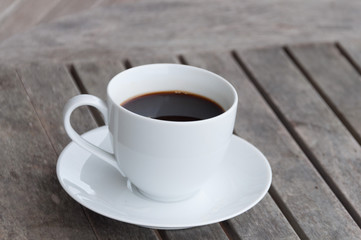 white cup of coffee on wooden table, soft focus