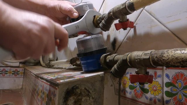 A plumber installs the meter of hot water