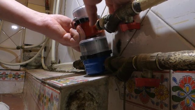 A plumber installs the meter of hot water
