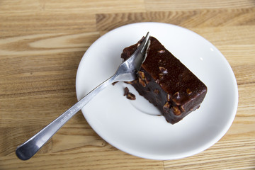 Plug breaks off piece of chocolate cake with nuts
