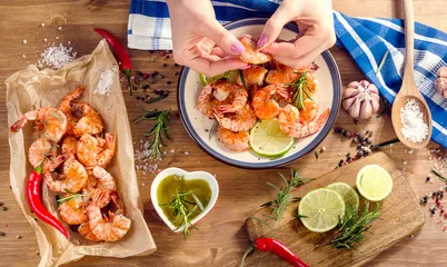 Gordijnen Woman hands with grilled shrimps. Healthy eating  concept. © bit24
