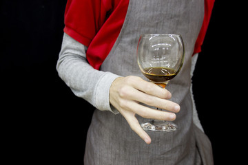 barista's hand holding glass of unfinished coffee