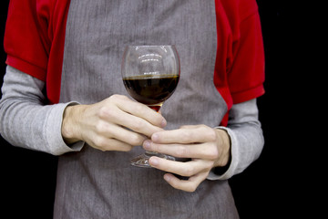 Glass of coffee or wine in hands of barista