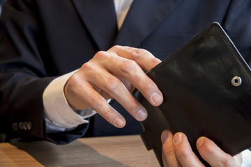 Businessman in cafe opens wallet