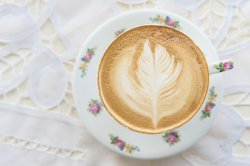 Hot Latte  art coffee in the vintage cup on the table