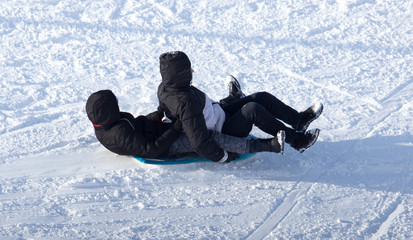 Fototapeta na wymiar two guy riding the hills on sleds