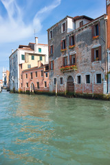 Fototapeta na wymiar Old houses by Canal Grande in a summer day in Venice