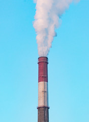white industrial smoke from the chimney on a blue sky