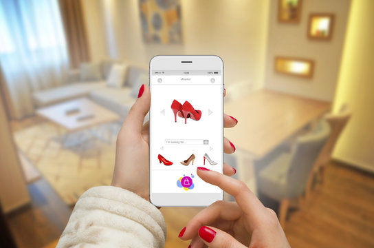 Women in apartment shopping online on modern white phone 