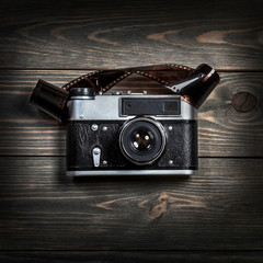 Retro film photo camera on the wooden background.