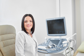 Fototapeta na wymiar Brunette doctor at cabinet against ultrasound equipment.