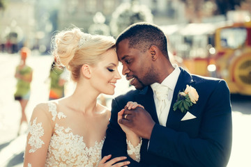Loving couple of cute bride and african American groom