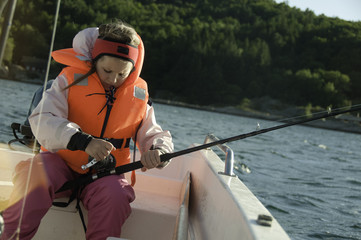 Girl with a fishing rod in a boat