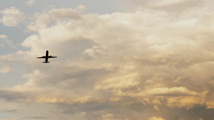Passenger airplane taking off at sunset against the background of a very beautiful clouds.