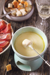 Cheese fondue with baguette and glass of white wine