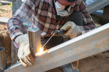 Welder at the factory working with metal construction
