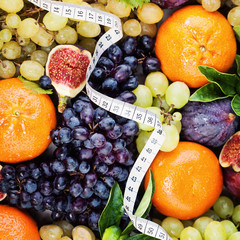Fresh Fruit Background with White Measuring Tape. Diet and Fitness Concept