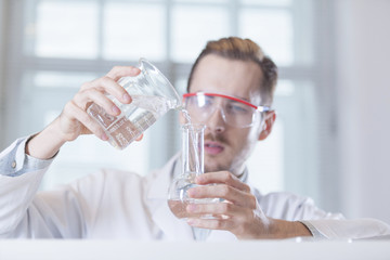 scientist pouring liquid