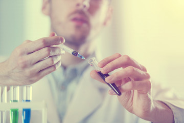 the doctor fills the vial from the syringe