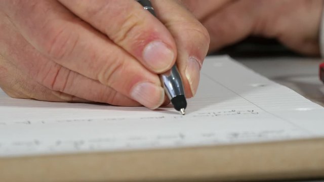close up of hand of man taking notes