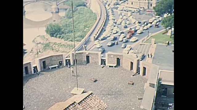 Skyline of Rome with Saint Peter church on top of Castel Sant'Angelo castle of Roma in Italy. City car traffic and canons tower. Historic restored footage on 1967.