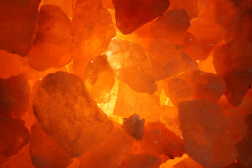 Background of salt crystals with orange lighting in the lamp. Close-up