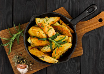 Roasted potato with fresh rosemary in cast-iron pan. Top view.