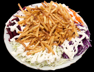 dish of fries with mayonnaise and vegetables on a black background