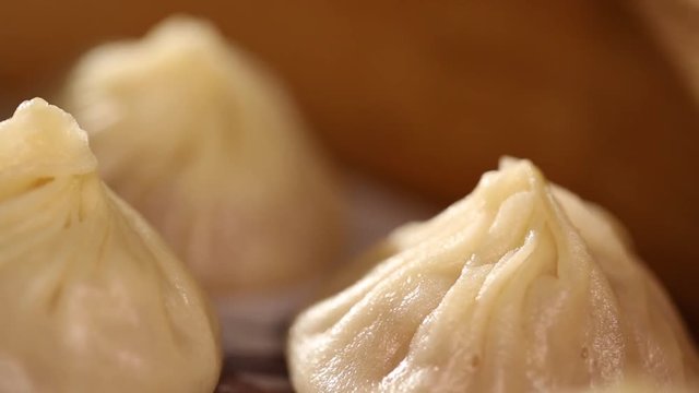 Close up of dumplings spinning in a bamboo steamer basket. The chinese dumpling generally consists of minced meat and finely chopped vegetables wrapped into a piece of dough skin.