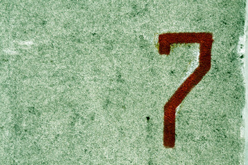 Number seven on grungy cement wall.
