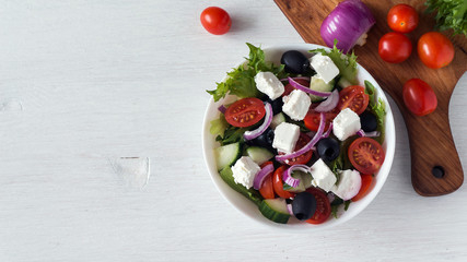 Fresh Greek salad in a white bowl. Top view, copy space for text