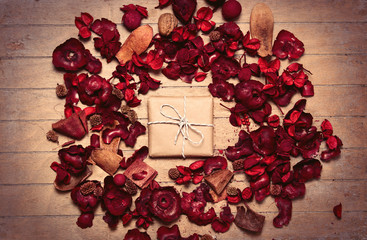 beautiful gift and romantic dried flower petals on the wonderful brown wooden background