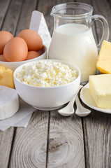 Fresh dairy products. Milk, cheese, brie, Camembert, butter, yogurt, cottage cheese and eggs on wooden table.